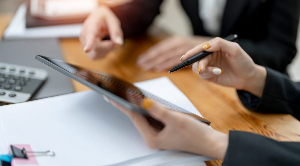 Professionals reviewing information on a tablet in an office setting